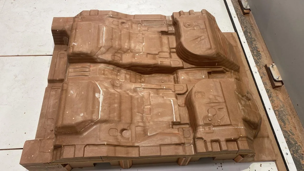 Modelo de peça automotiva em MDF, com o relevo usinado em CNC
