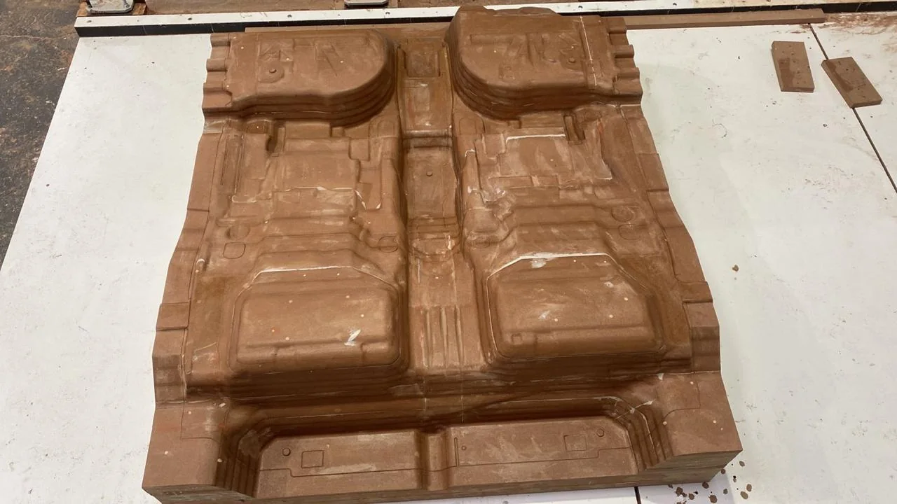 Par de modelos automotivos em MDF usinados em CNC, sobre a bancada