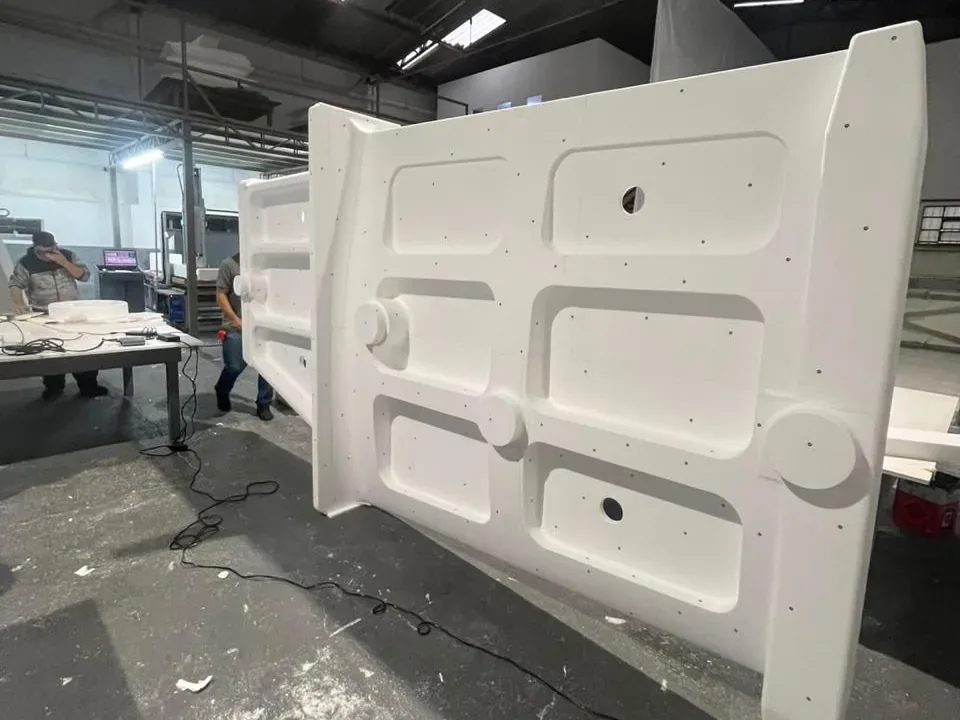 Molde em EPS para termoformagem de painel veicular, com dois funcionários ao lado dando a escala da peça